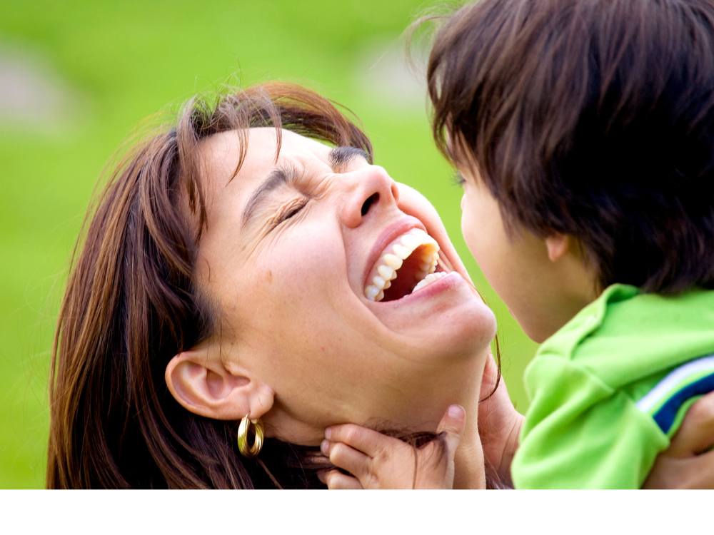 Mother and son sharing a joyful laugh outdoors